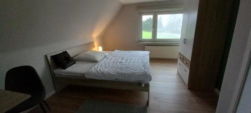 a small bedroom with a bed and a window at zum Kranichblick in Glinstedt