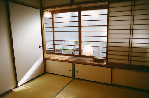 a room with a window with a table and a lamp at Hakonowa in Hakone