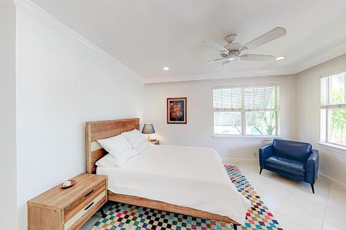 a bedroom with a bed and a blue chair at Pineapple Place in Fort Lauderdale
