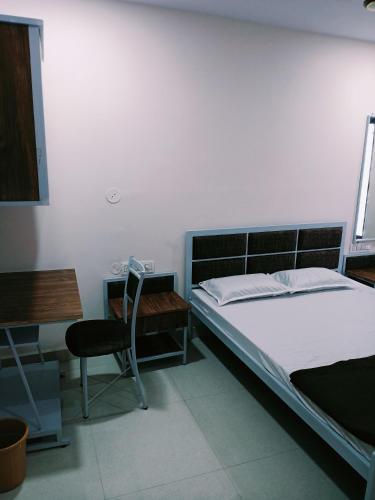 a bedroom with a bed and a desk and a chair at Anand P G hostel males only in Nagpur