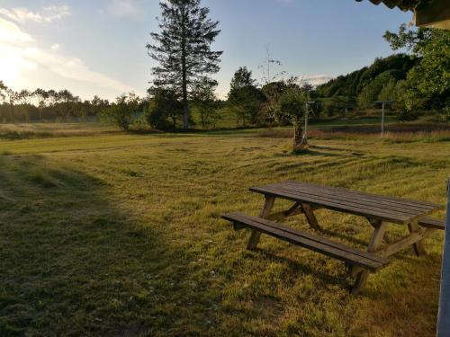 a wooden picnic table sitting in a field at Hærvejsly - Perfekt familiebase til oplevelse af Sydjylland in Give