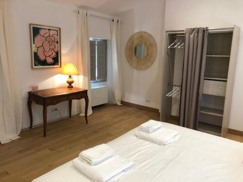 a bedroom with a bed and a table with towels at Villa du defens in Saint-Martin-de-Castillon