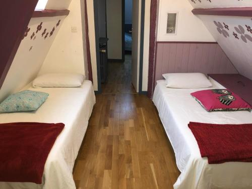 two beds in a small room with wooden floors at Le tilleul de St Julien in Saint-Julien-de-Chédon