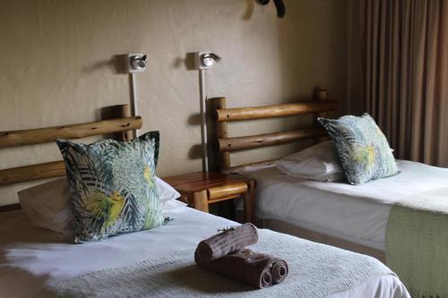a hotel room with two beds with towels on the bed at Outspan Safaris in Komga