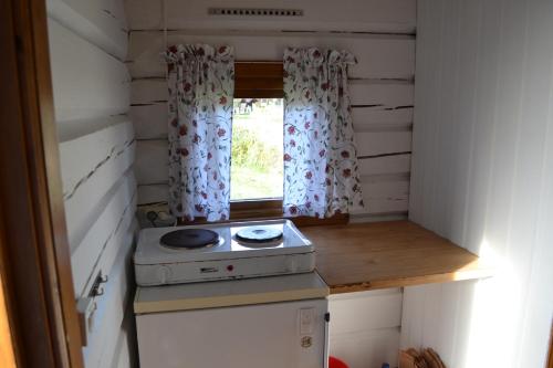 a tiny kitchen with a stove and a window at First Camp Enåbadet - Rättvik in Rättvik