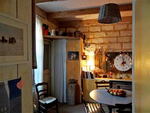 a kitchen with a table and a clock on the wall at Chambre d'hôte Farniente in Aigues-Mortes