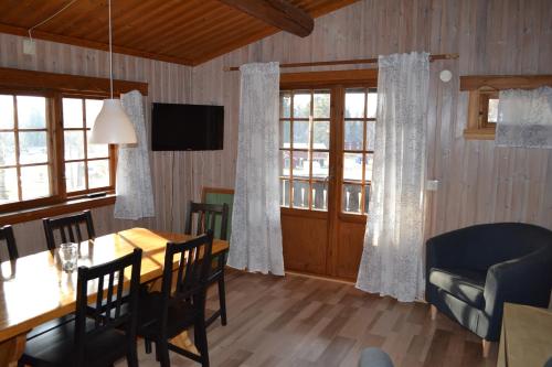 a dining room with a table and chairs and windows at First Camp Enåbadet - Rättvik in Rättvik