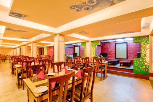 a restaurant with tables and chairs in a room at Summit Ttakshang Residency Hotel & Spa Mg Marg in Gangtok