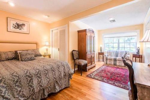 a bedroom with a bed and a chair and a window at Unwind Island in West Palm Beach