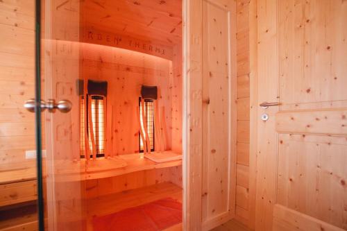 een inloopdouche in een houten kamer met spiegels bij Brandhof in Ischgl