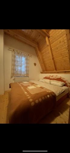 Un dormitorio con una cama grande en un ático. en Vikendica Vjeverica, en Risovac