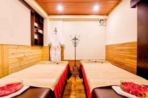 a room with two beds and a mannequin in it at Summit Ttakshang Residency Hotel & Spa Mg Marg in Gangtok
