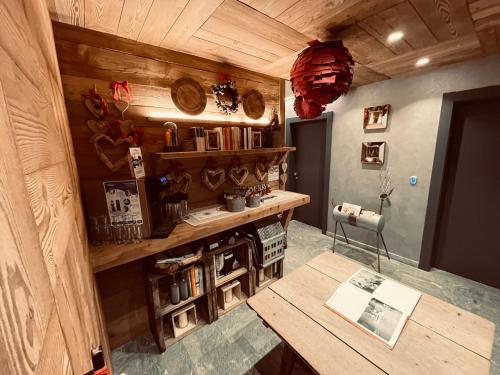 una habitación con una mesa y un estante con libros en MH Olen Boutique Hotel, en Alagna Valsesia