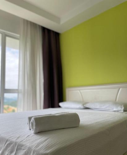 a towel laying on a bed in a bedroom at Sky Bungalow NIlai by James NEARBY KLIA, KLIA 2, CYBERJAYA, PUTRAJAYA in Nilai