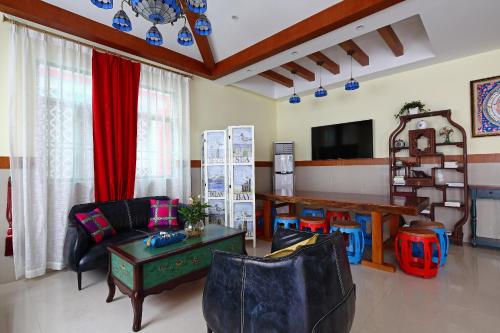 a living room with chairs and a table and a tv at Shenzhen Xichong beach Lanting Homestay in Dapengcheng