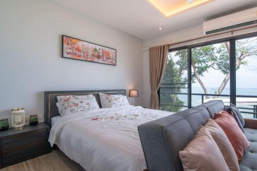 a bedroom with a bed and a large window at Koh Sirey Beachfront Pool Villa in Phuket Town