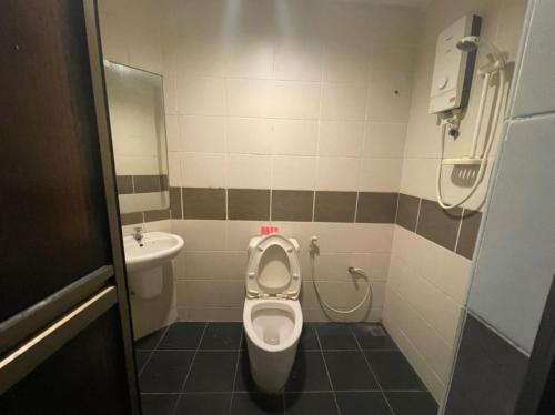 ein Bad mit einem WC und einem Waschbecken in der Unterkunft OYO 90411 Perdana Hotel Labuan in Labuan