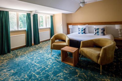 um quarto de hotel com uma cama e duas cadeiras em Restaurant & Hotel Hoog Holten em Holten