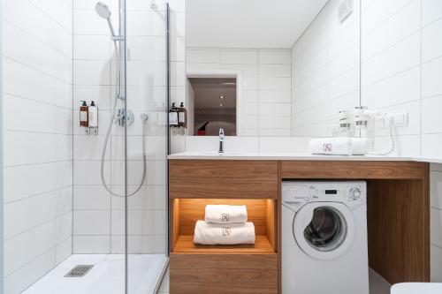 łazienka z pralką i prysznicem w obiekcie City Apartments - Apartamenty Butikowe w Koszalinie