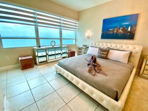 a bedroom with a large bed with a large window at Castle Beach Resort Condo - Panoramic Large Penthouse or Deluxe 1 BR Direct Ocean View and beach access- Updated-Free parking- in Miami Beach
