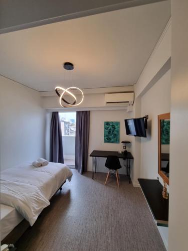 a bedroom with a bed and a desk at Savoy Hotel in Piraeus