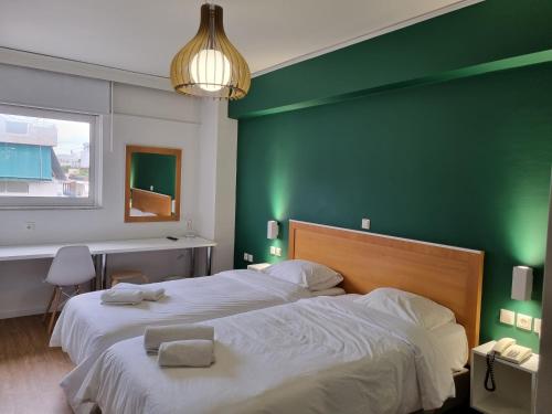 a bedroom with a large bed with a green wall at Savoy Hotel in Piraeus