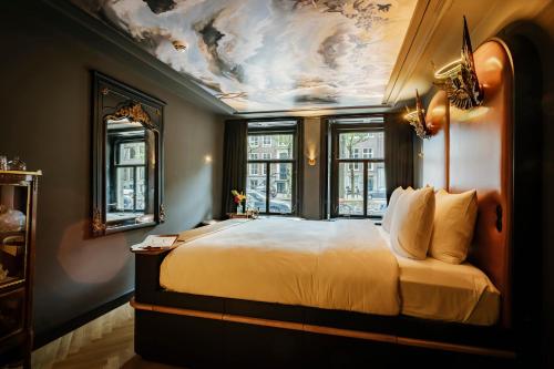a bedroom with a large bed with a painting on the ceiling at Boutique Hotel The Noblemen in Amsterdam
