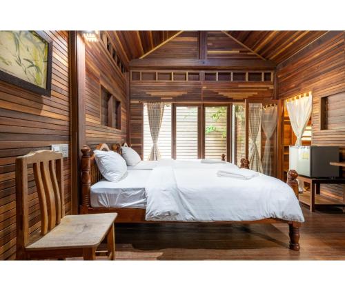 a bedroom with a bed in a room with wooden walls at Mac Garden Resort in Ban Phe