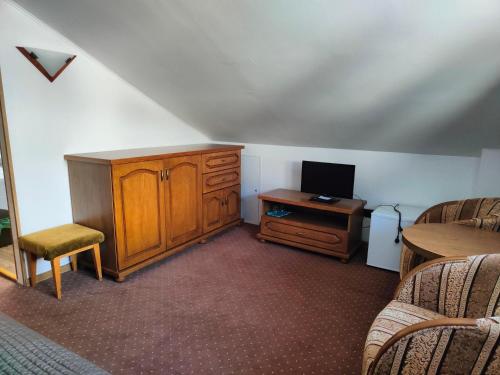 a room with a desk and a tv and a cabinet at Penzión Encián in Tatranská Lomnica