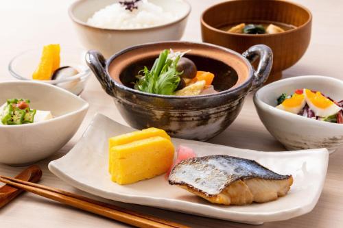 a table with a plate of food and bowls of food at remm Hibiya in Tokyo