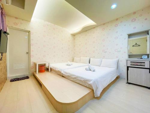 a bedroom with a large bed and a television at Fengjia Jocy House in Taichung