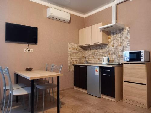una pequeña cocina con mesa y microondas en Guest house on Kamyshovaya 12 a, en Adler