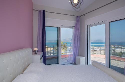 a bedroom with a bed and a view of the ocean at Villa Danae in Laganas