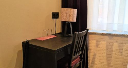 a black desk with a lamp on top of it at Pension Schmatka Matka in Lutherstadt Eisleben