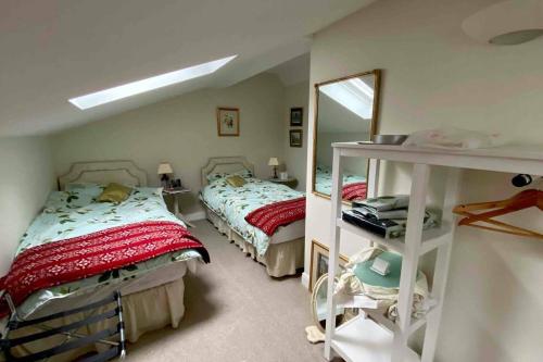 1 dormitorio con 2 camas y espejo en Luxury Accom with Pool Henbury Macclesfield en Alderley Park
