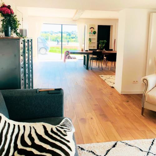a living room with a zebra print couch and a table at Little Farm Comfort&PrestigeHouse in Ittre