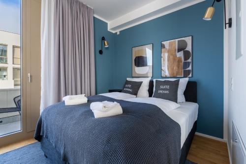 a bedroom with two beds with blue walls at Limehome Potsdam Annemarie-Wolff-Platz in Potsdam