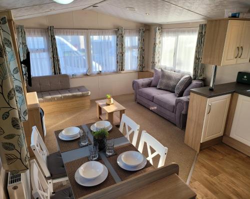 uma cozinha e sala de estar com mesa e cadeiras em Lovely Static Caravan at Billing Aquadrome em Great Billing