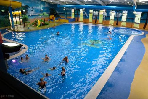 um grupo de pessoas a nadar numa piscina em Lovely Static Caravan at Billing Aquadrome em Great Billing