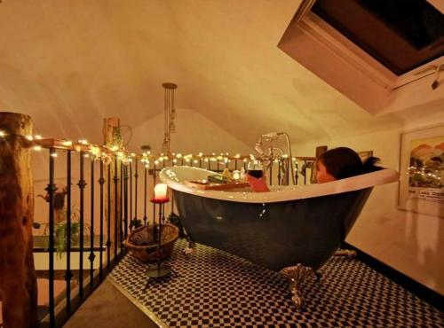 a woman sitting in a bath tub in a room at Rosie's Barn in Penrith