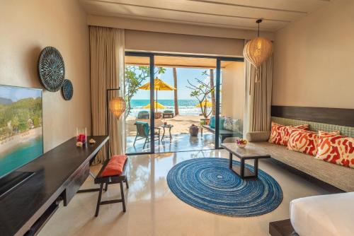 a living room with a view of the beach at Buri Rasa Village Phangan in Thong Nai Pan Noi