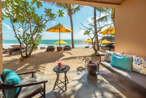 a living room with a couch and a view of the beach at Buri Rasa Village Phangan in Thong Nai Pan Noi