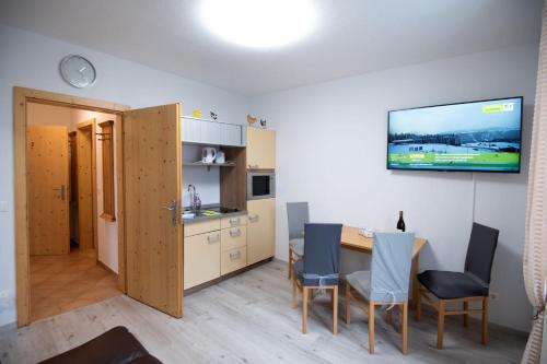 a kitchen and dining room with a table and chairs at Apartmenthaus HAUS Gipfelglück Apartment KUAFSTOA in Haus im Ennstal