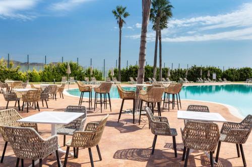 a group of tables and chairs next to a pool at Melia Villaitana in Benidorm