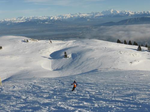 a person riding skis down a snow covered slope at Aparthotel Adagio Geneve Saint Genis Pouilly in Thoiry