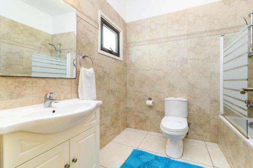 a bathroom with a toilet and a sink and a shower at Protaras Centro Villa in Protaras