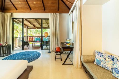 a living room with a couch and a table at Buri Rasa Village Phangan in Thong Nai Pan Noi