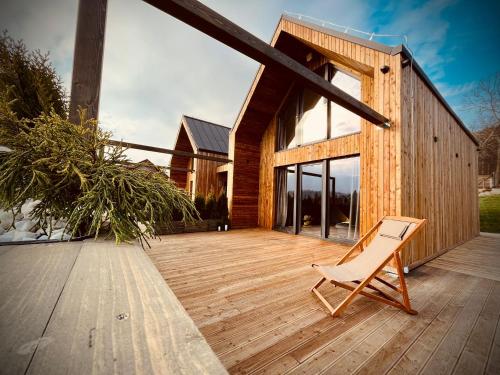 a chair sitting on the deck of a house at Osada Źródlana in Kowary
