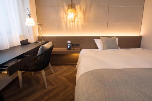 a bedroom with a bed and a desk with a piano at Hotel Global View Hakodate in Hakodate