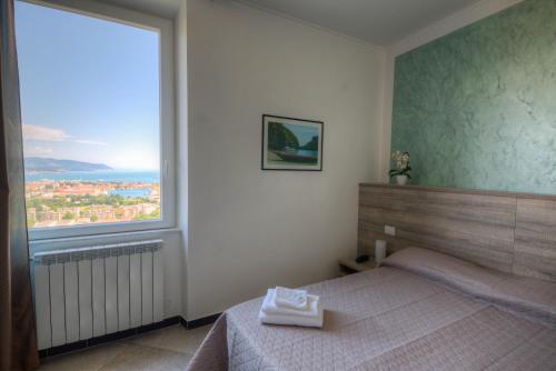 a bedroom with a bed and a large window at 88 Miglia in La Spezia